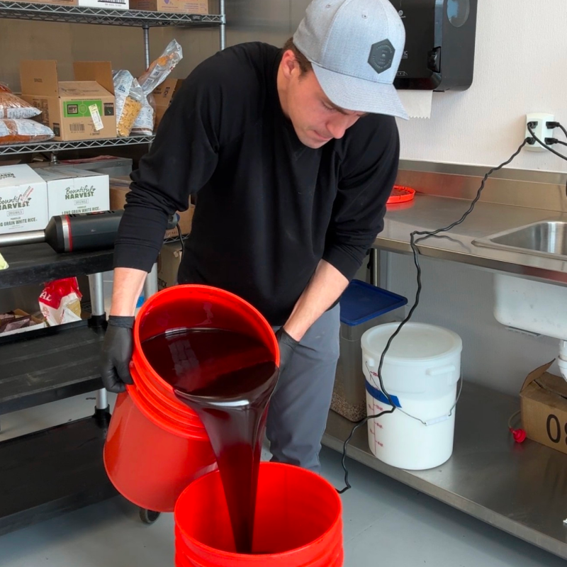 Drew pouring energy gel mixture in the commercial kitchen