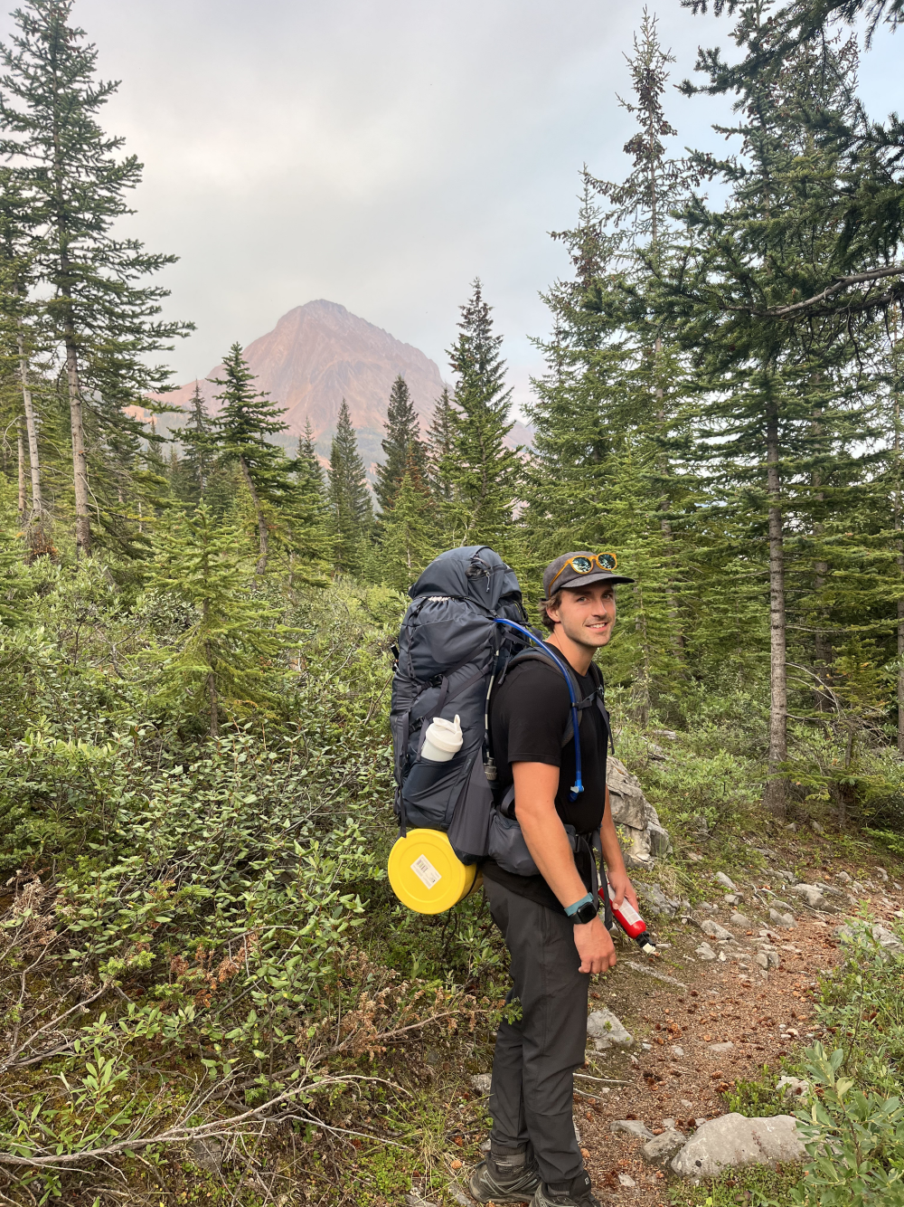 Drew, founder of TIDLØS, backpacking in the mountains